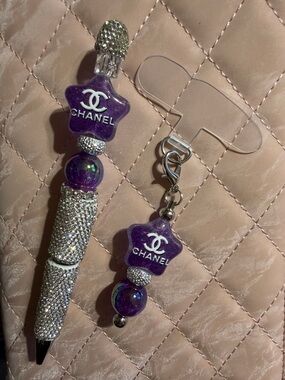 Purple and silver rhinestone pen with rose topper and matching phone charm.